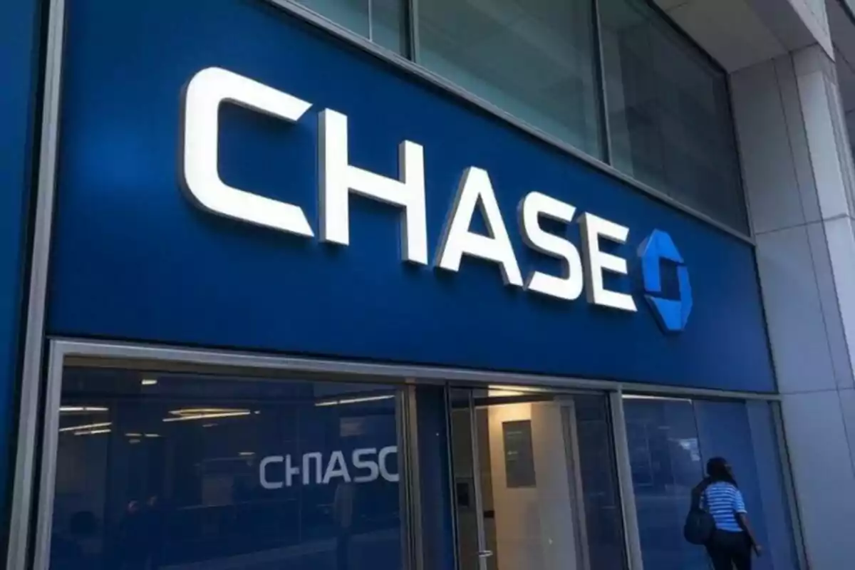 Fachada de una sucursal bancaria con el logotipo de Chase en letras grandes y una persona entrando al edificio.