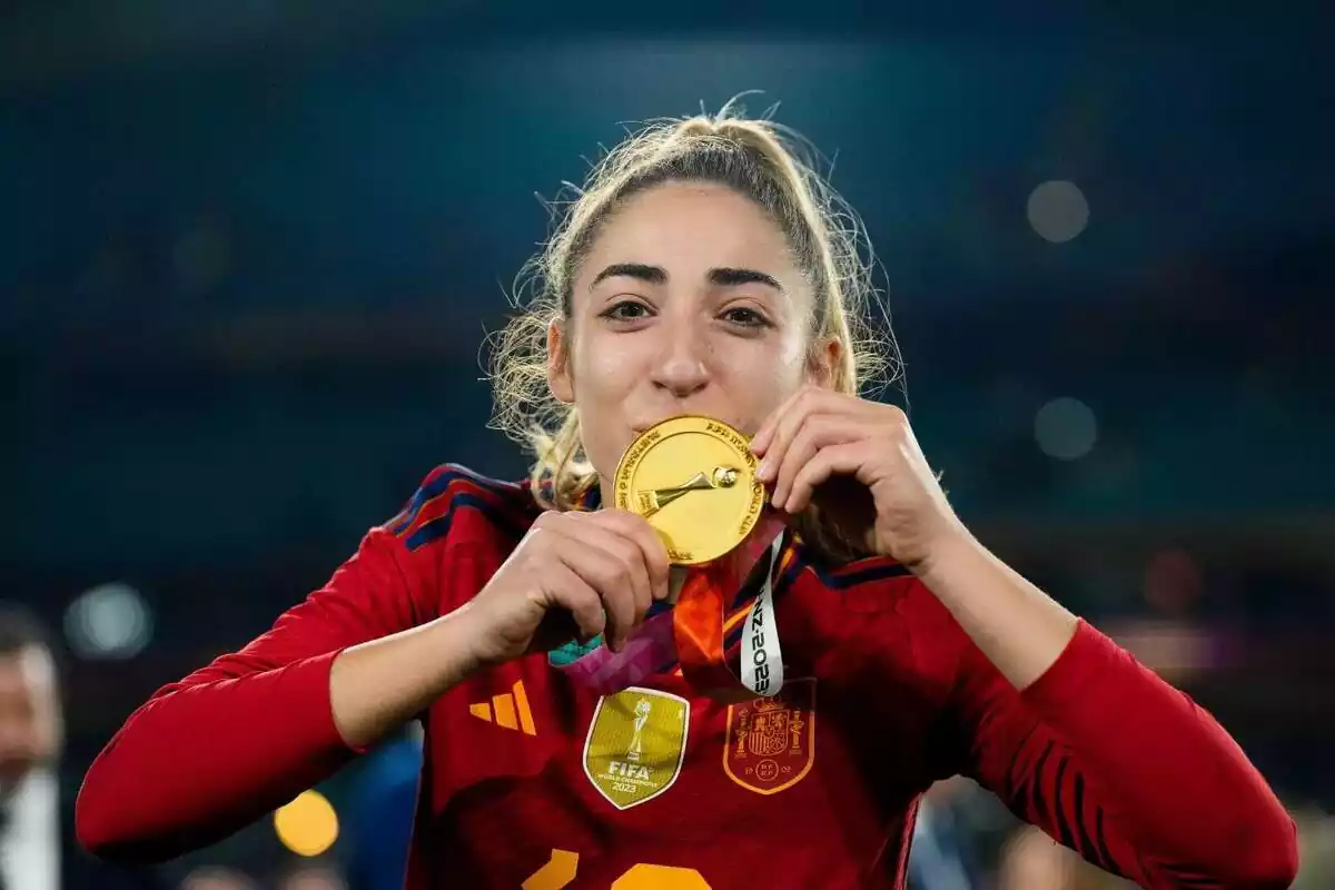 Olga Carmona besant la medalla d'or del Mundial de Futbol Femení