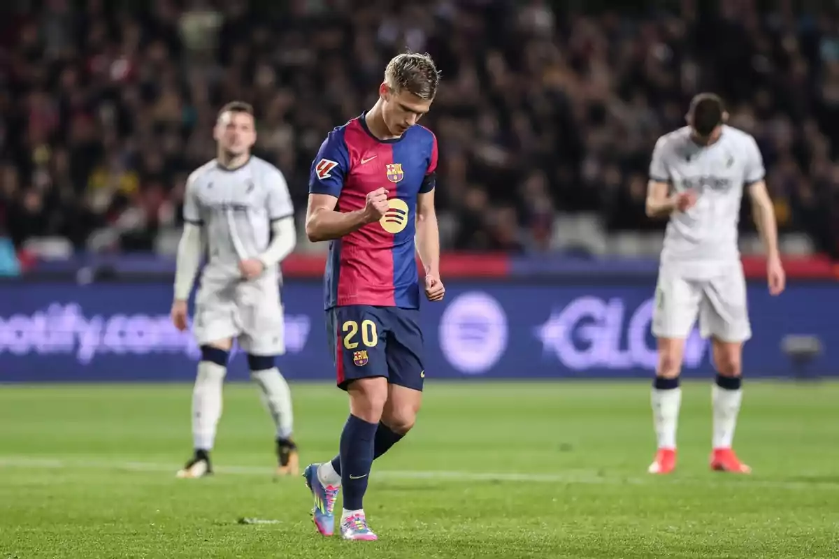 A player from Barcelona celebrates on the field while other players are in the background. A player from Barcelona celebrates on the field while other players are in the background.