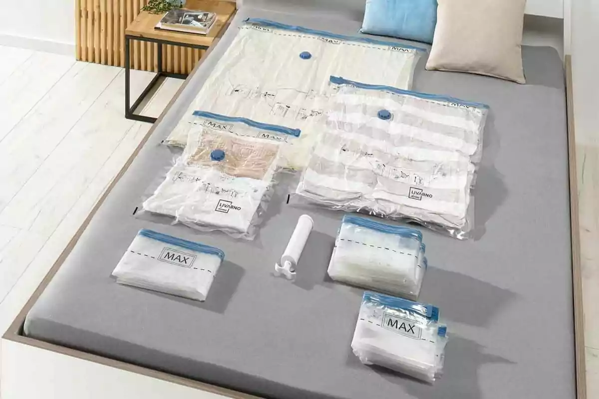 Pack de bosses d'emmagatzematge al buit de Lidl amb una bomba manual sobre un llit. Pack de bosses d'emmagatzematge al buit de Lidl amb una bomba manual sobre un llit.