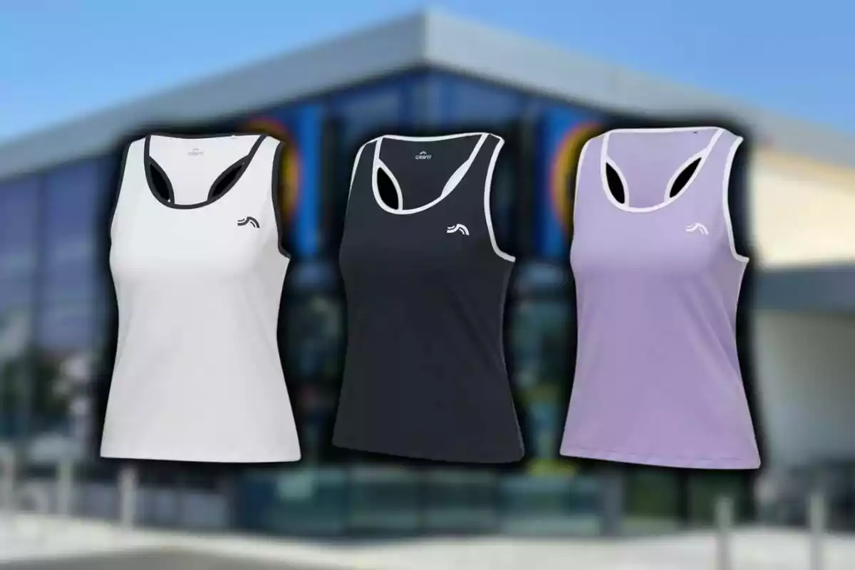 Tres samarretes esportives sense mànigues en colors blanc, negre i lila de Lidl davant d'un dels seus supermercats. Tres samarretes esportives sense mànigues en colors blanc, negre i lila de Lidl davant d'un dels seus supermercats.