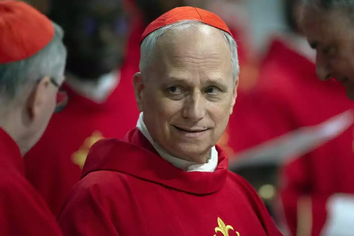 A man in red religious attire and a red zucchetto on his head, surrounded by other people in similar outfits. A man in red religious attire and a red zucchetto on his head, surrounded by other people in similar outfits.