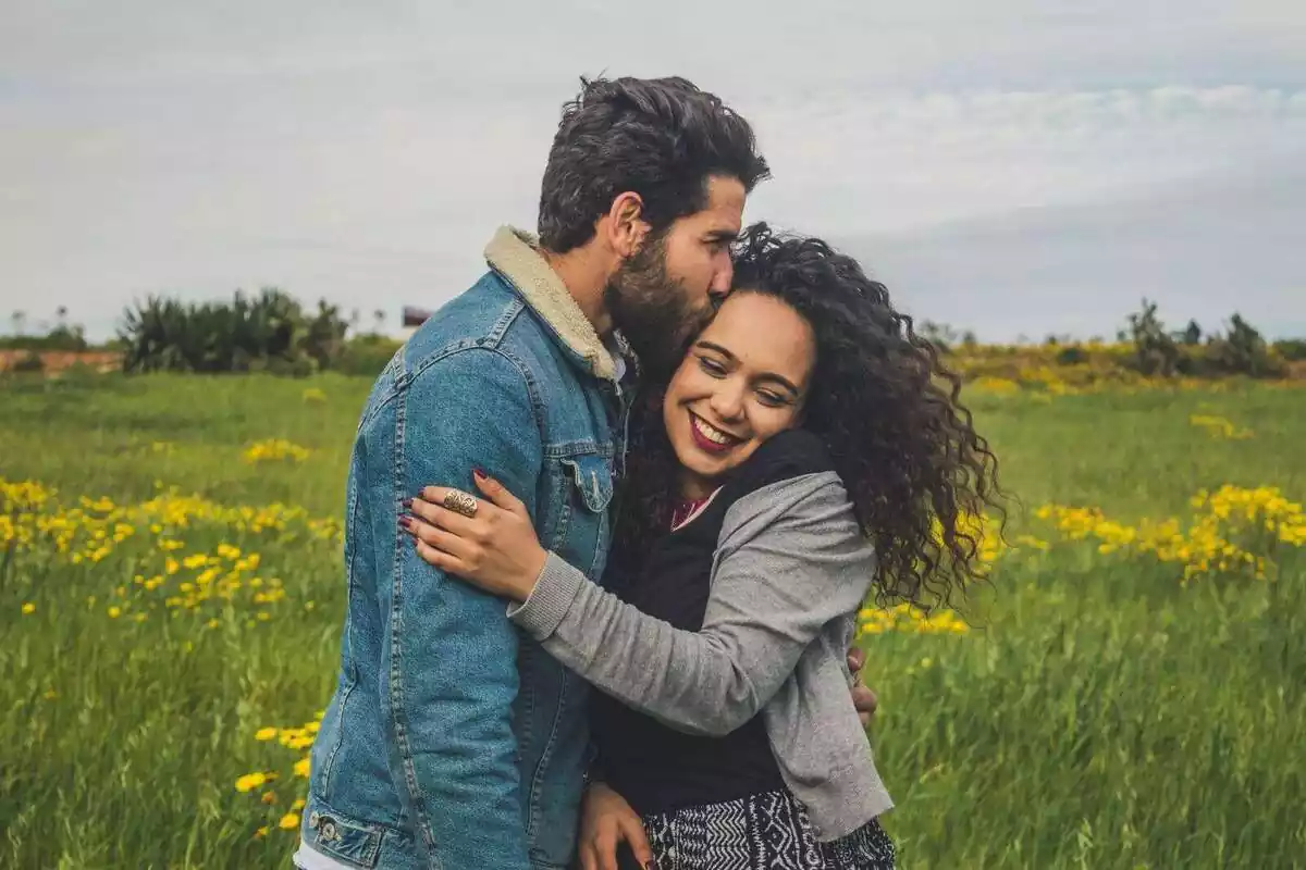 Pareja feliz abrazada en medio del campo