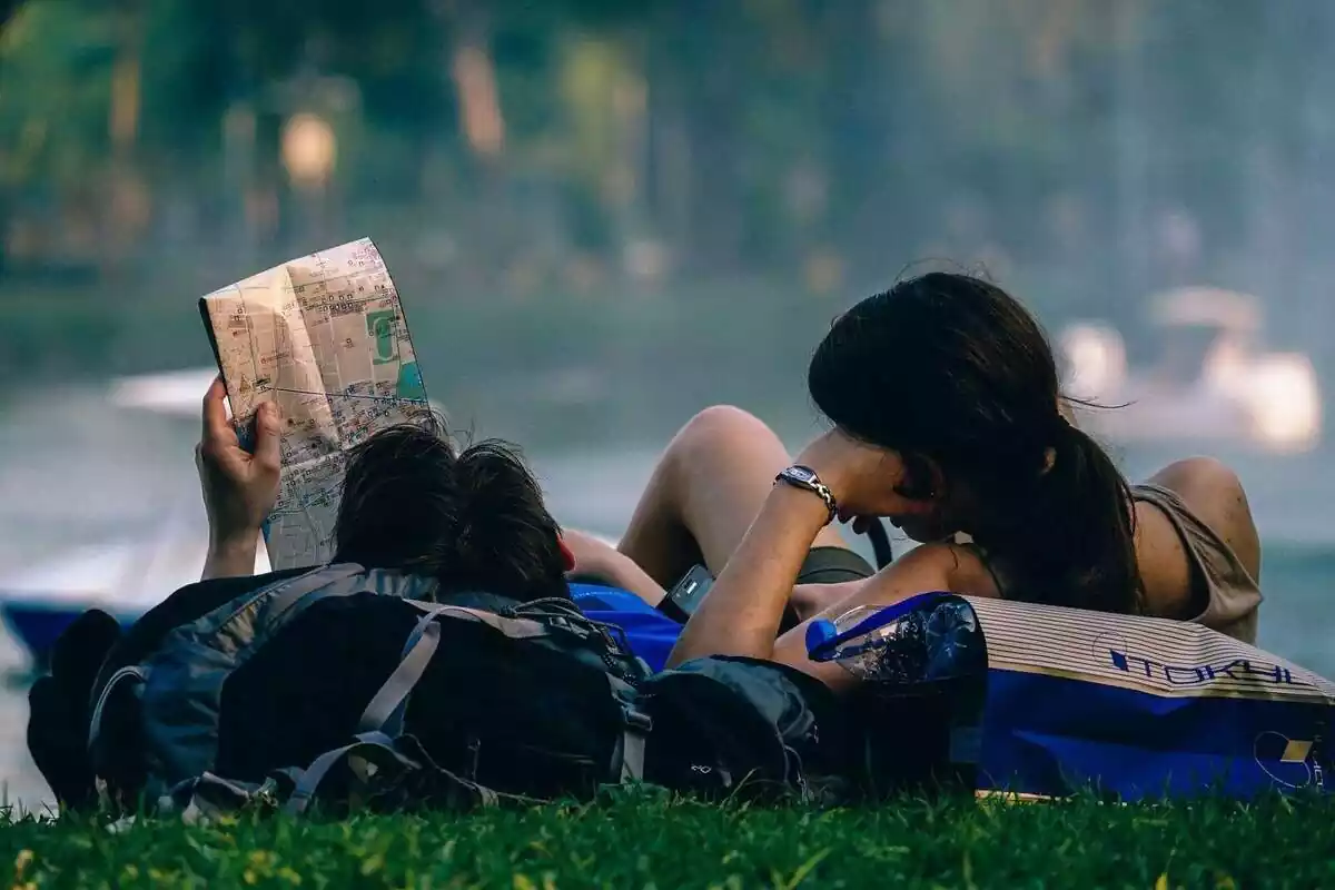 Una pareja tumbada mirando un mapa