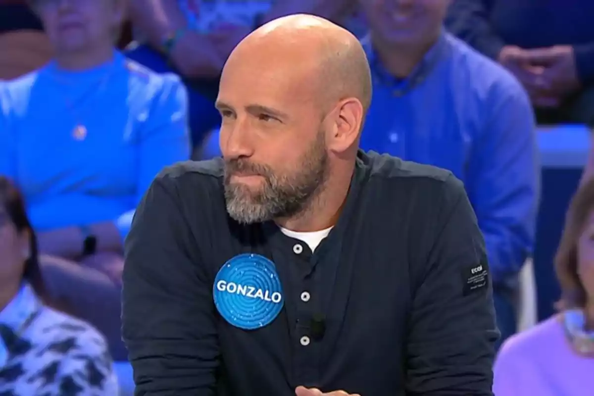 Gonzalo Miró amb samarreta fosca participant en un concurs de televisió amb una xapa blava que diu Gonzalo i públic de fons. Captura de 'Pasapalabra' Gonzalo Miró amb samarreta fosca participant en un concurs de televisió amb una xapa blava que diu Gonzalo i públic de fons. Captura de 'Pasapalabra'