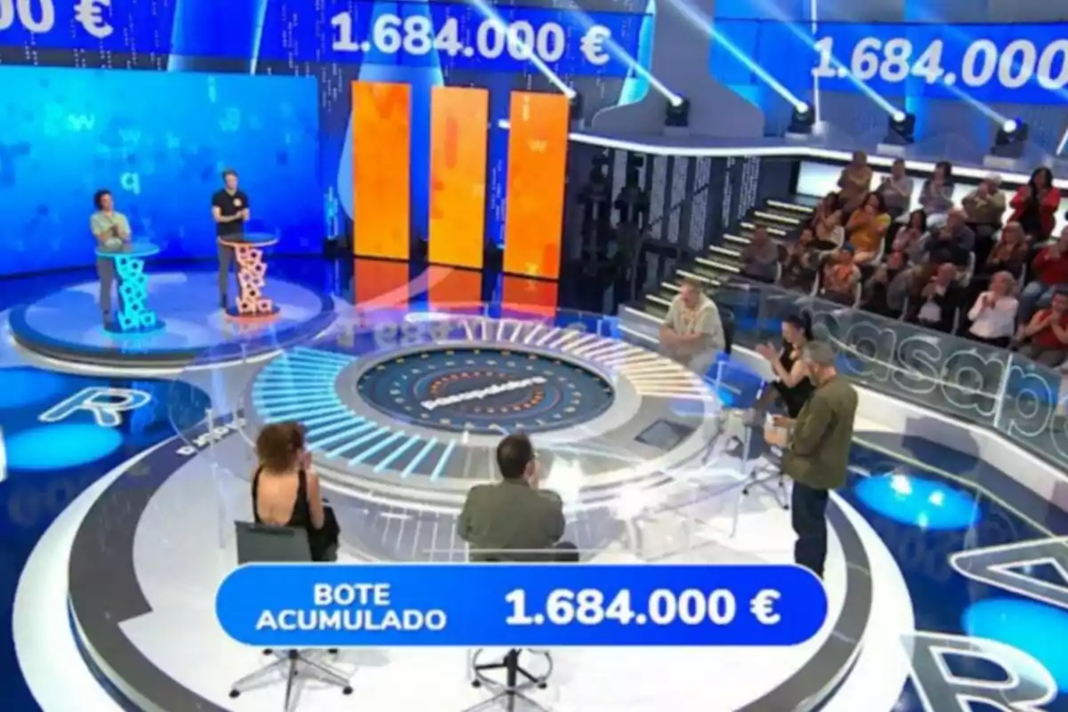 Concurs televisiu amb participants en un plató modern, públic al fons i un pot acumulat de 1.684.000 euros en pantalla. Captura de 'Pasapalabra' Concurs televisiu amb participants en un plató modern, públic al fons i un pot acumulat de 1.684.000 euros en pantalla. Captura de 'Pasapalabra'