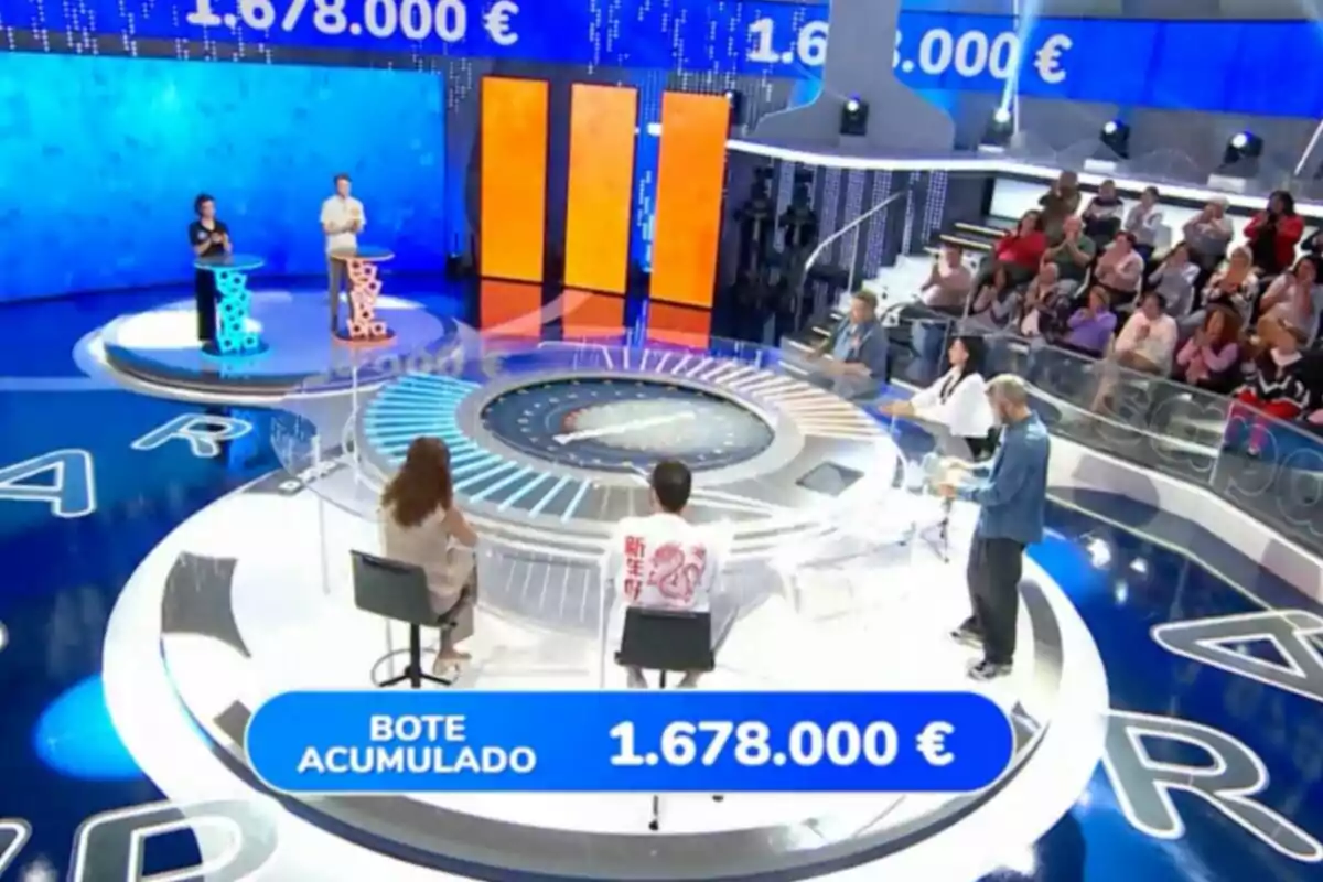 Un plató de concurs televisiu amb concursants, presentador, públic i un pot acumulat d’un milió sis-cents setanta-vuit mil euros en pantalla. Captura de ‘Pasapalabra’ Un plató de concurs televisiu amb concursants, presentador, públic i un pot acumulat d’un milió sis-cents setanta-vuit mil euros en pantalla. Captura de ‘Pasapalabra’