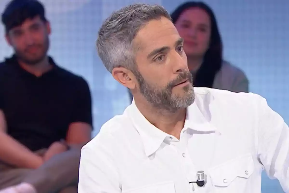 Roberto Leal està assegut en un estudi de televisió, vestint una camisa blanca, mentre dues persones estan desenfocades al fons. Captura de 'Pasapalabra'. Roberto Leal està assegut en un estudi de televisió, vestint una camisa blanca, mentre dues persones estan desenfocades al fons. Captura de 'Pasapalabra'.