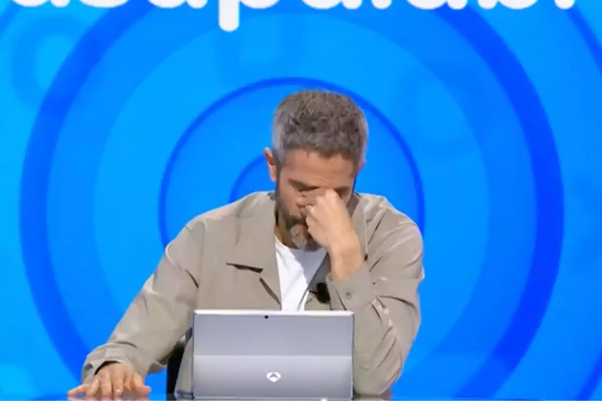 Roberto Leal assegut davant d’un ordinador amb un gest de frustració i un fons blau amb cercles concèntrics. Captura de ‘Pasapalabra’. Roberto Leal assegut davant d’un ordinador amb un gest de frustració i un fons blau amb cercles concèntrics. Captura de ‘Pasapalabra’.