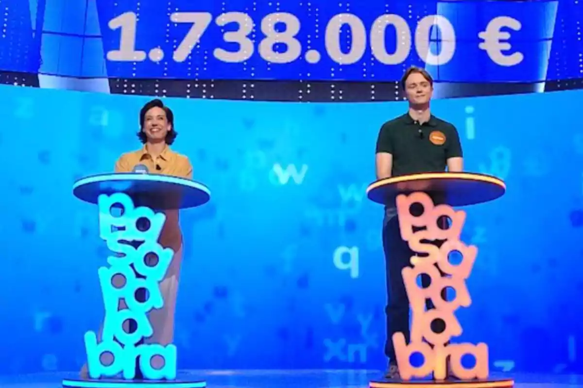 Rosa i Manu drets en un plató de televisió amb decorat blau i la xifra d’1.738.000 euros en gran sobre ells. Captura de ‘Pasapalabra’ Rosa i Manu drets en un plató de televisió amb decorat blau i la xifra d’1.738.000 euros en gran sobre ells. Captura de ‘Pasapalabra’