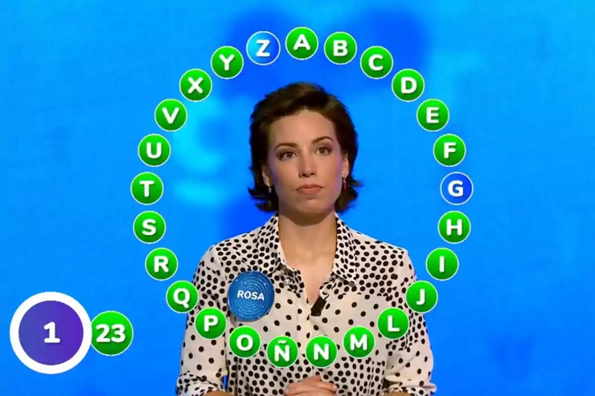 Rosa competing on a TV show with alphabet letters in a circle around her and a blue background. Screenshot from 'Pasapalabra'
