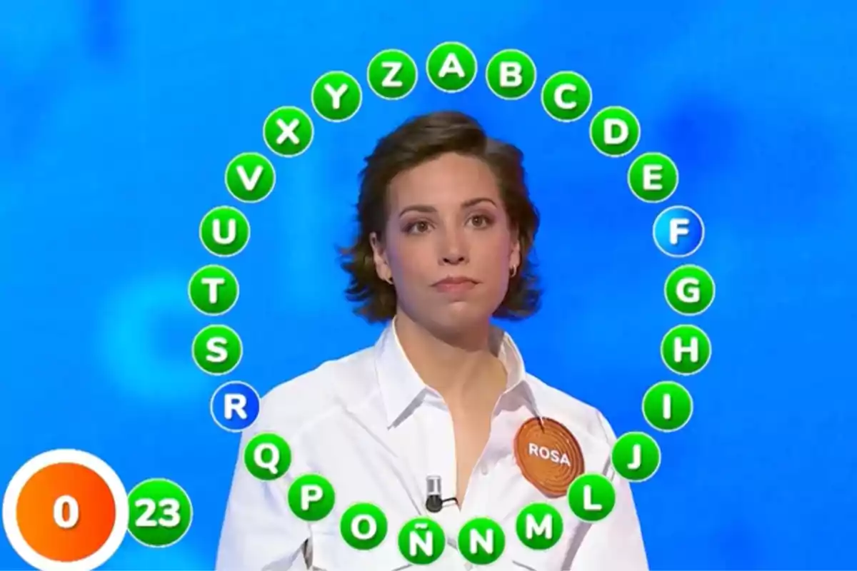 Rosa en un programa de televisió amb lletres de l'abecedari en un cercle al seu voltant i un cronòmetre a la cantonada inferior esquerra. Captura de 'Pasapalabra'. Rosa en un programa de televisió amb lletres de l'abecedari en un cercle al seu voltant i un cronòmetre a la cantonada inferior esquerra. Captura de 'Pasapalabra'.