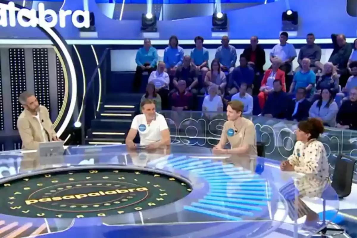 Un grup de persones participa en un programa de televisió, asseguts al voltant d'una taula circular amb un públic al fons. Captura de 'Pasapalabra'. Un grup de persones participa en un programa de televisió, asseguts al voltant d'una taula circular amb un públic al fons. Captura de 'Pasapalabra'.
