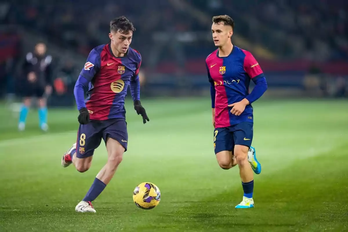 Dos futbolistas con uniforme azul y rojo jugando en un campo de fútbol. Dos futbolistas con uniforme azul y rojo jugando en un campo de fútbol.
