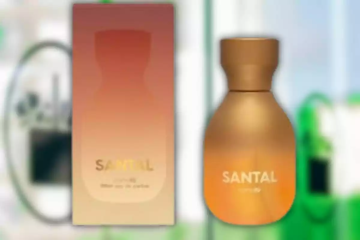 Una ampolla de perfum daurada al costat de la seva caixa amb un disseny degradat en tons càlids. Una ampolla de perfum daurada al costat de la seva caixa amb un disseny degradat en tons càlids.