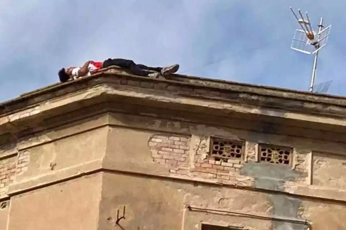 Una persona dormint a la teulada d'un edifici a Tortosa