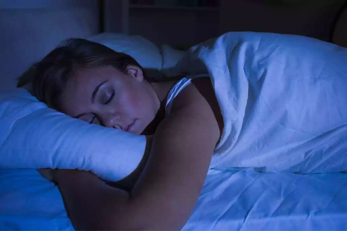 Dona jove dormint profundament sense llum artificial