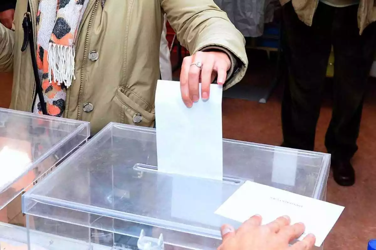 Persona introduint el vot en una urna electoral
