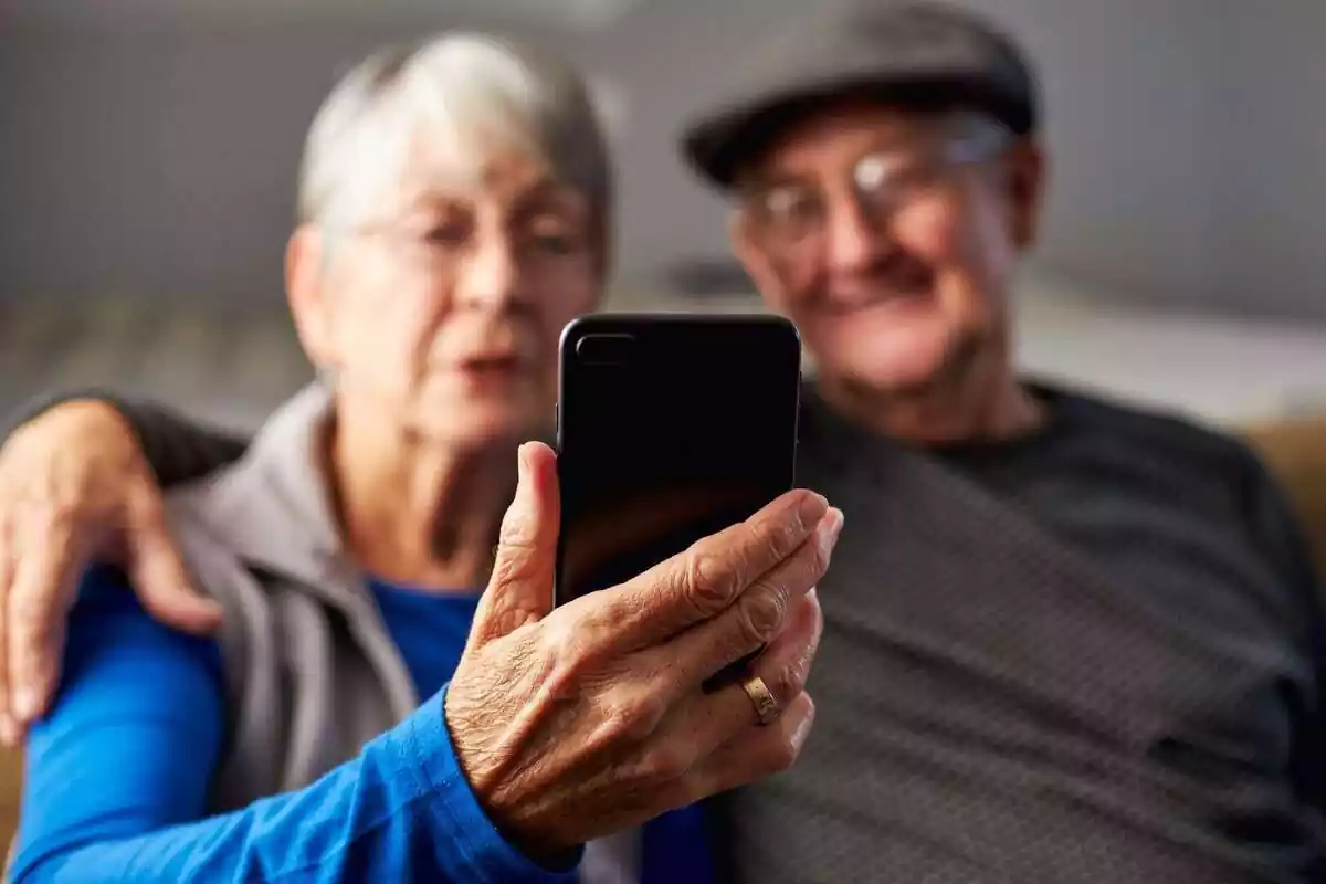 Dues persones grans mirant la pantalla d'un mòbil