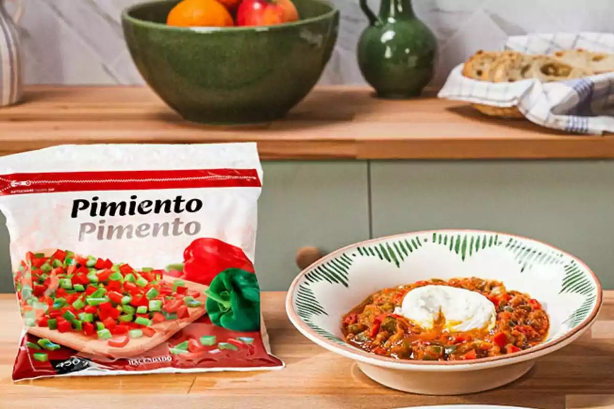 Un paquet de pebrots picats al costat d'un plat de menjar amb pebrots i un ou poché en una cuina amb fruites i pa al fons. Un paquet de pebrots picats al costat d'un plat de menjar amb pebrots i un ou poché en una cuina amb fruites i pa al fons.