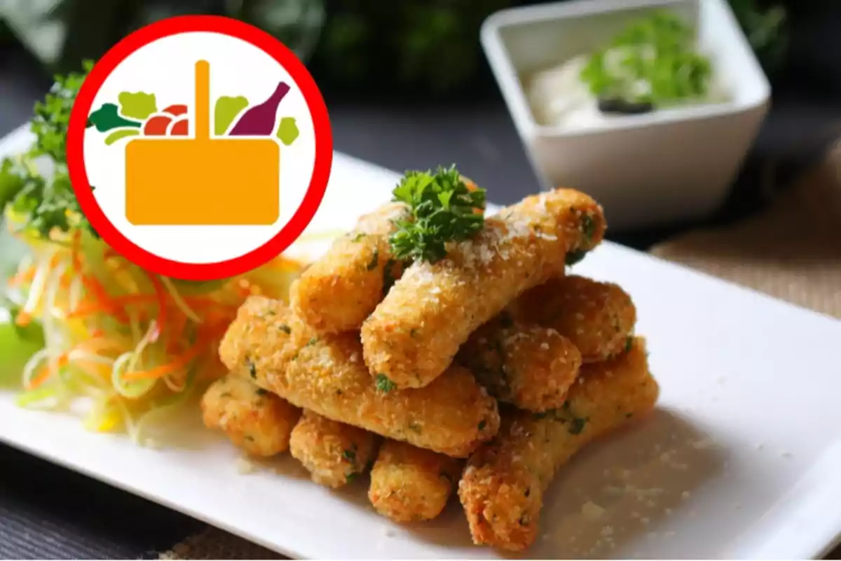 Un plat de croquetes daurades apilades amb julivert a sobre, acompanyat d'una amanida de verdures fresques i un recipient amb salsa al fons, al costat d'una icona de cistell de la compra amb aliments. Un plat de croquetes daurades apilades amb julivert a sobre, acompanyat d'una amanida de verdures fresques i un recipient amb salsa al fons, al costat d'una icona de cistell de la compra amb aliments.
