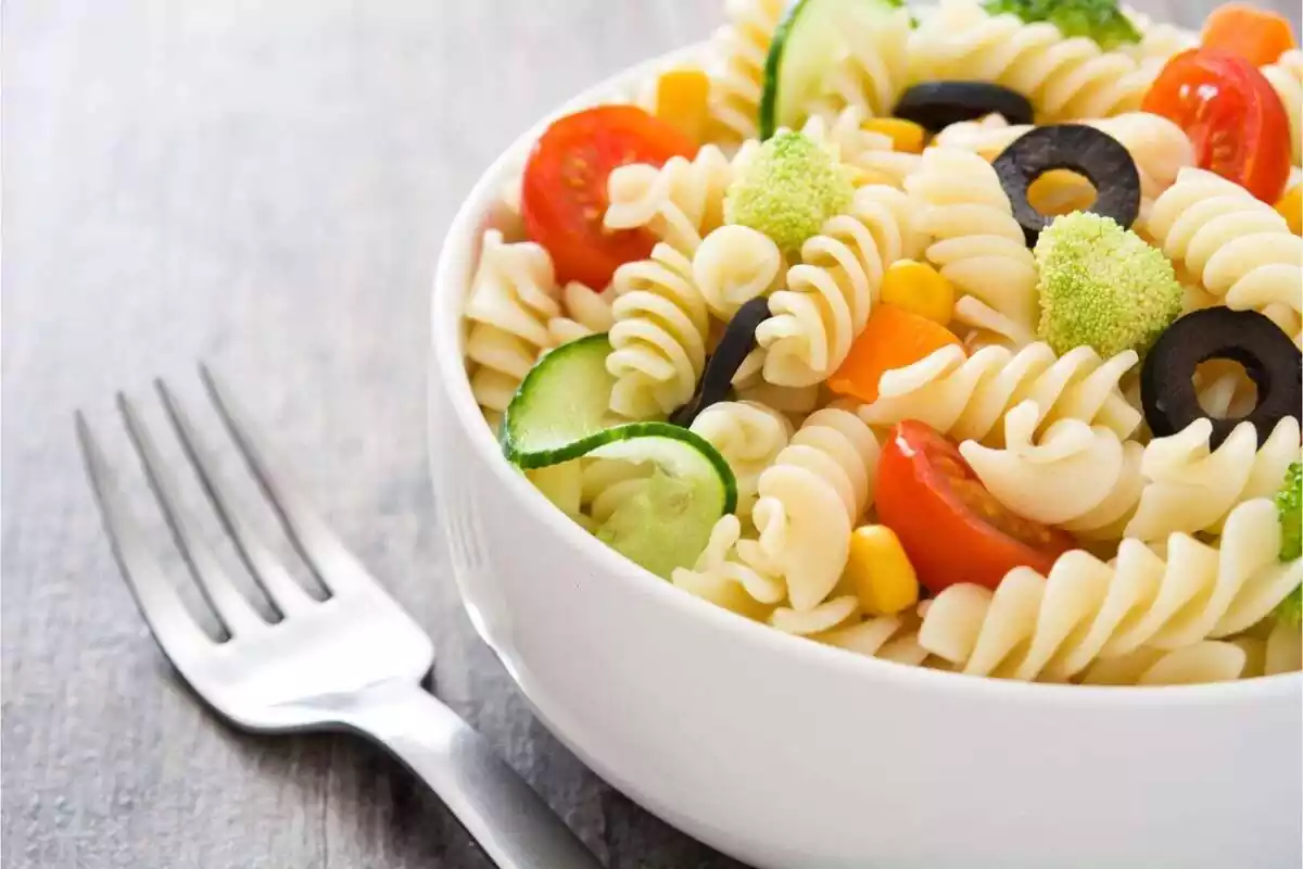 Plat d'amanida de pasta juntament amb una forquilla Plat d'amanida de pasta juntament amb una forquilla