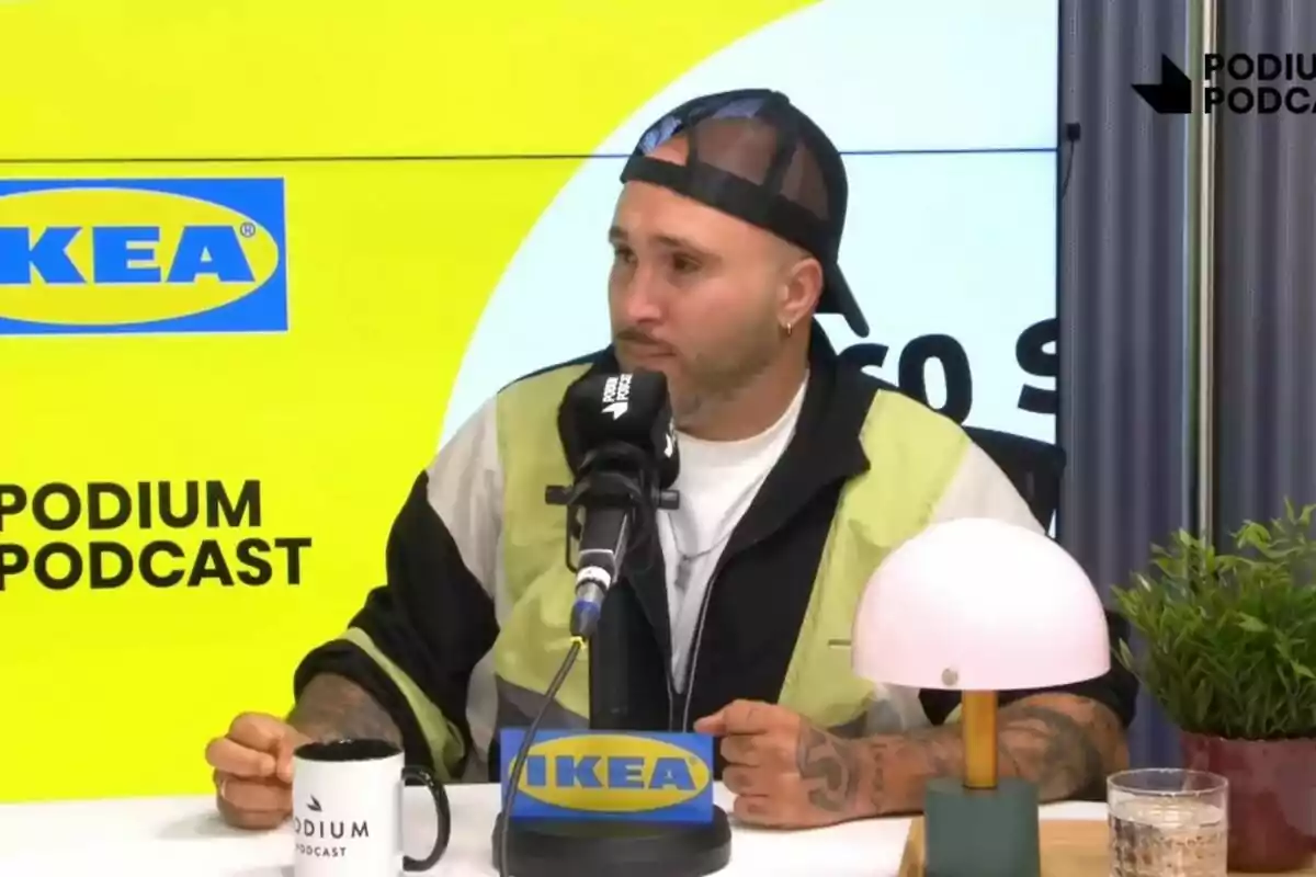 Kiko Rivera amb gorra al revés participa en un podcast davant d'un micròfon amb logos d'IKEA i Podium Podcast.