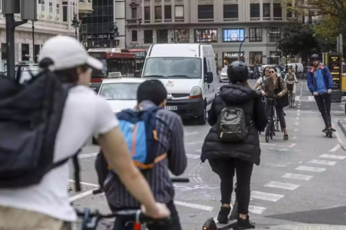 Pas de vianants amb persones circulant en diferents tipus de transport