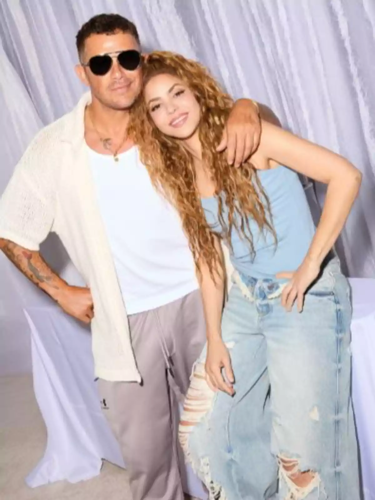 Alejandro Sanz i Shakira posen juntes, una amb ulleres de sol i roba casual, l'altra amb els cabells arrissats i texans esquinçats, ambdues somriuen davant d'un fons clar. Alejandro Sanz i Shakira posen juntes, una amb ulleres de sol i roba casual, l'altra amb els cabells arrissats i texans esquinçats, ambdues somriuen davant d'un fons clar.