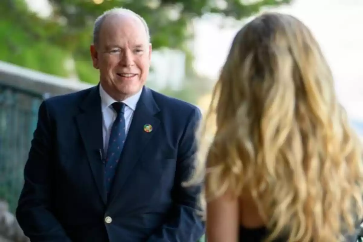 Albert de Mònaco amb vestit fosc somriu mentre conversa amb Cyrielle Hariel a l’aire lliure