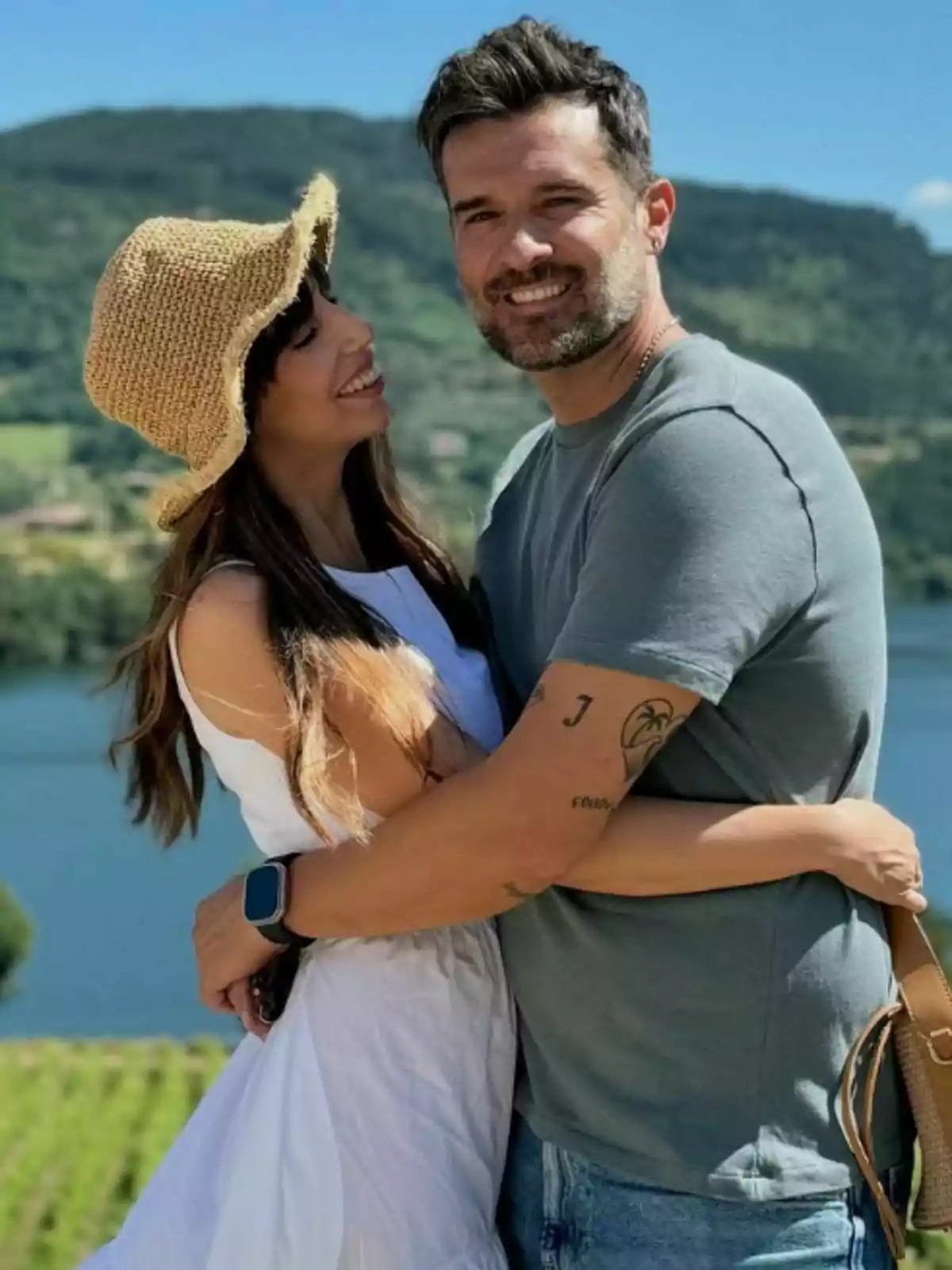 Almudena Cid i Gerardo Berodia somrient s'abracen a l'aire lliure amb un paisatge muntanyós i un llac de fons. Almudena Cid i Gerardo Berodia somrient s'abracen a l'aire lliure amb un paisatge muntanyós i un llac de fons.