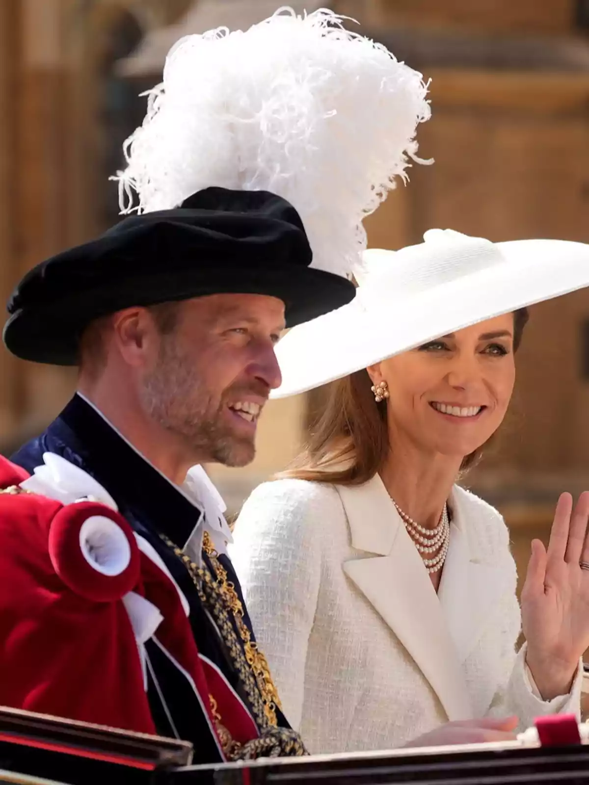 El príncep Guillem i la Kate Middleton, elegantment vestits, participen en un esdeveniment formal a l’aire lliure; una d’elles porta un barret blanc gran i l’altra un barret negre amb plomes blanques. El príncep Guillem i la Kate Middleton, elegantment vestits, participen en un esdeveniment formal a l’aire lliure; una d’elles porta un barret blanc gran i l’altra un barret negre amb plomes blanques.