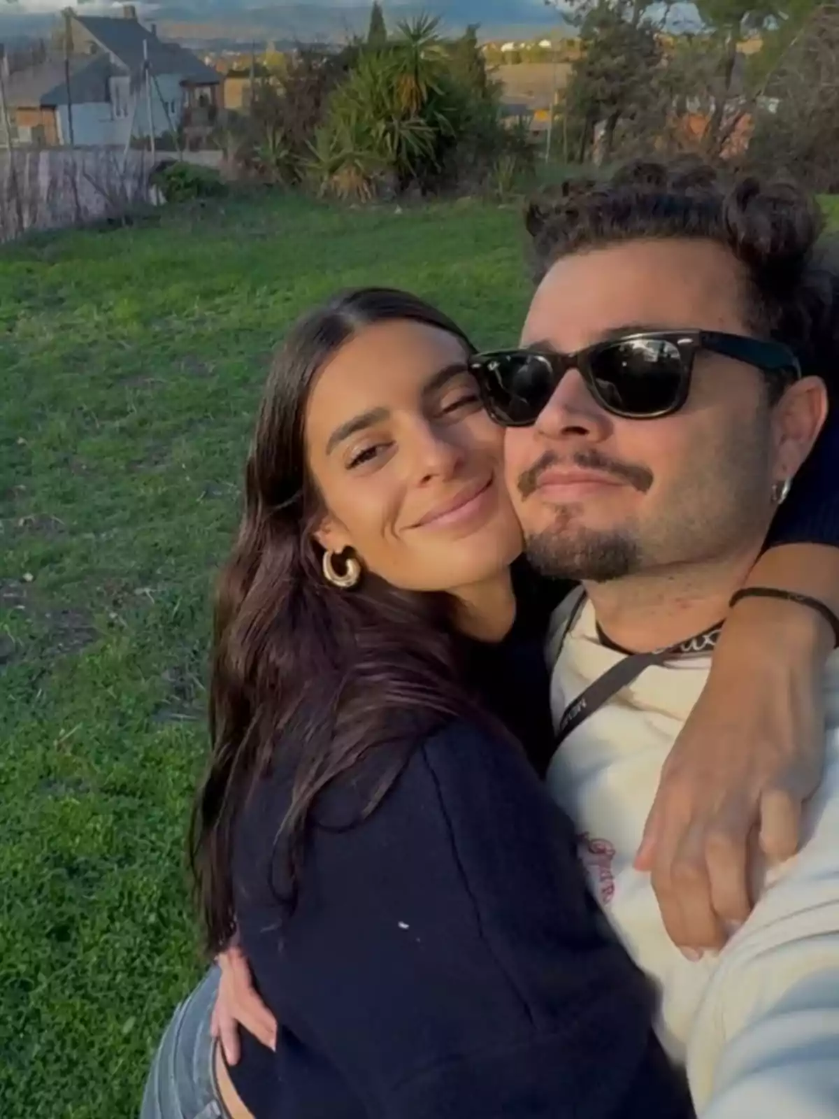 Susana Molina y su pareja abrazada sonriendo mientras se toman una selfie al aire libre en un campo verde Susana Molina y su pareja abrazada sonriendo mientras se toman una selfie al aire libre en un campo verde