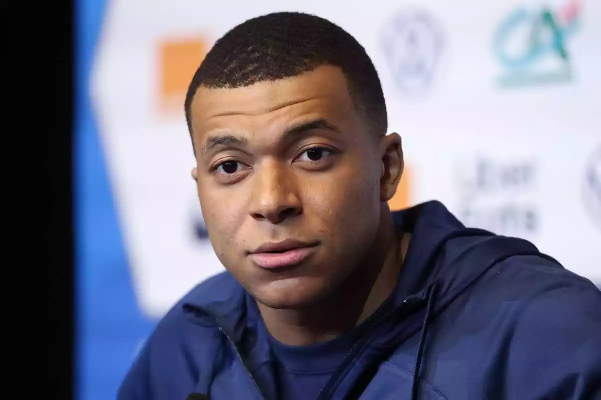 Primer pla de Kylian Mbappé amb rostre neutre i una jaqueta blava Primer pla de Kylian Mbappé amb rostre neutre i una jaqueta blava