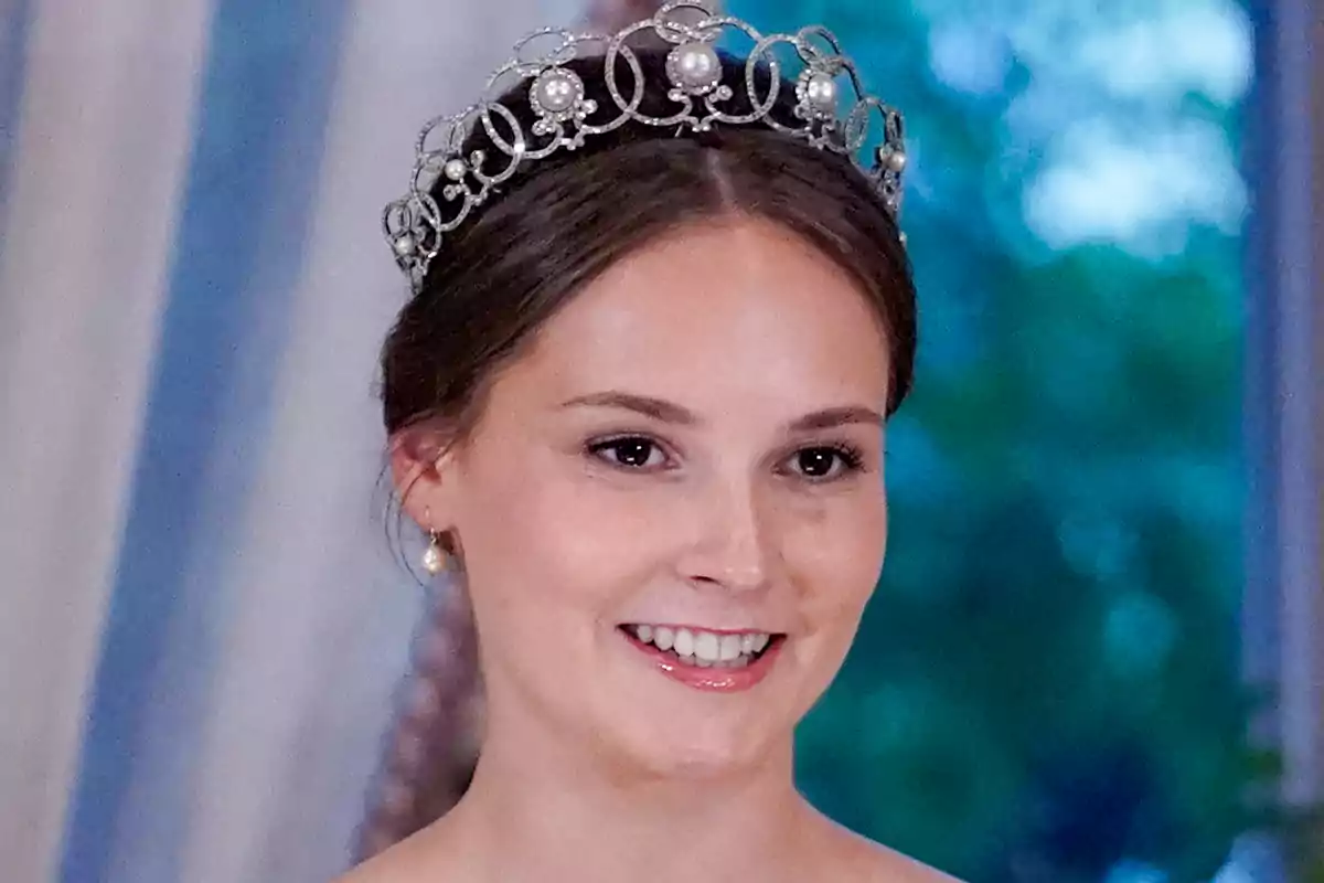 La princesa Ingrid Alexandra somrient porta una tiara elegant amb perles i detalls intricats, amb un fons desenfocat de tons blaus i verds. La princesa Ingrid Alexandra somrient porta una tiara elegant amb perles i detalls intricats, amb un fons desenfocat de tons blaus i verds.