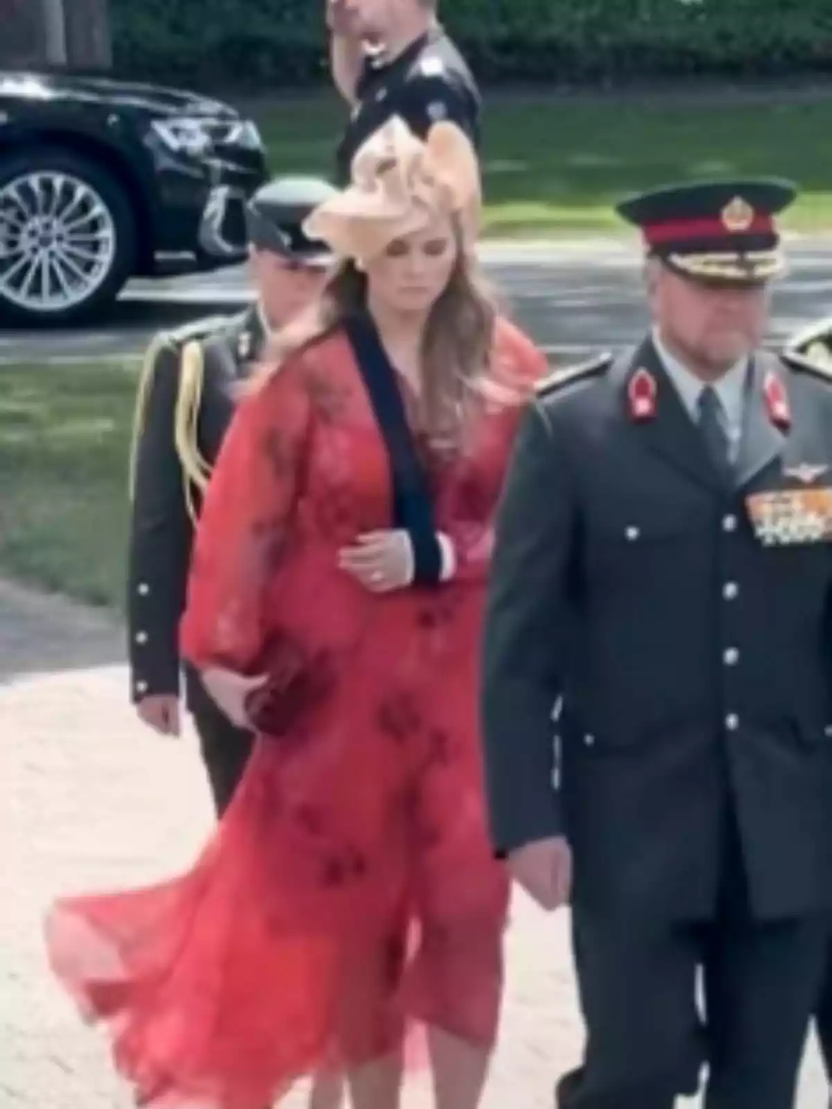 La princesa Amalia dels Països Baixos, vestida amb un vestit vermell i un barret elegant, camina al costat d’homes amb uniforme militar en un esdeveniment a l’aire lliure. La princesa Amalia dels Països Baixos, vestida amb un vestit vermell i un barret elegant, camina al costat d’homes amb uniforme militar en un esdeveniment a l’aire lliure.