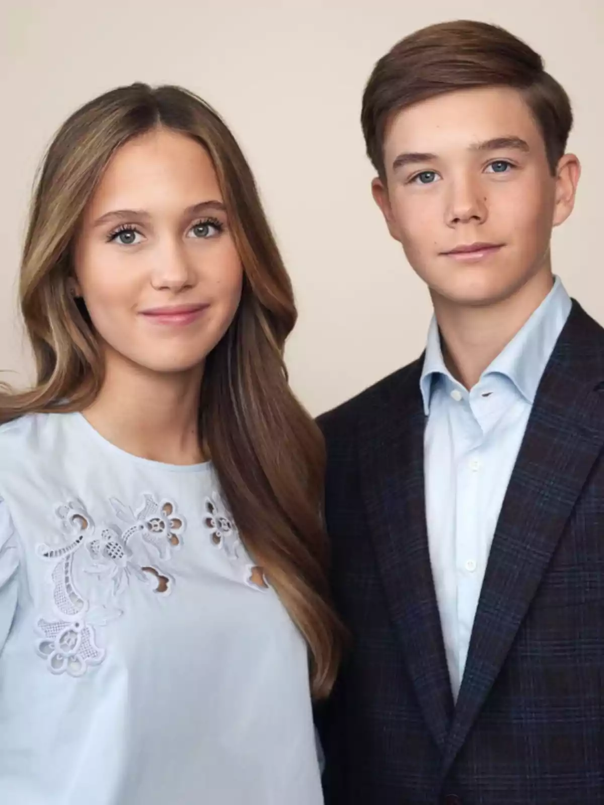 Dos adolescents posen junts mirant a la càmera, ella porta una brusa blava cel amb brodats i ell vesteix jaqueta fosca i camisa clara.