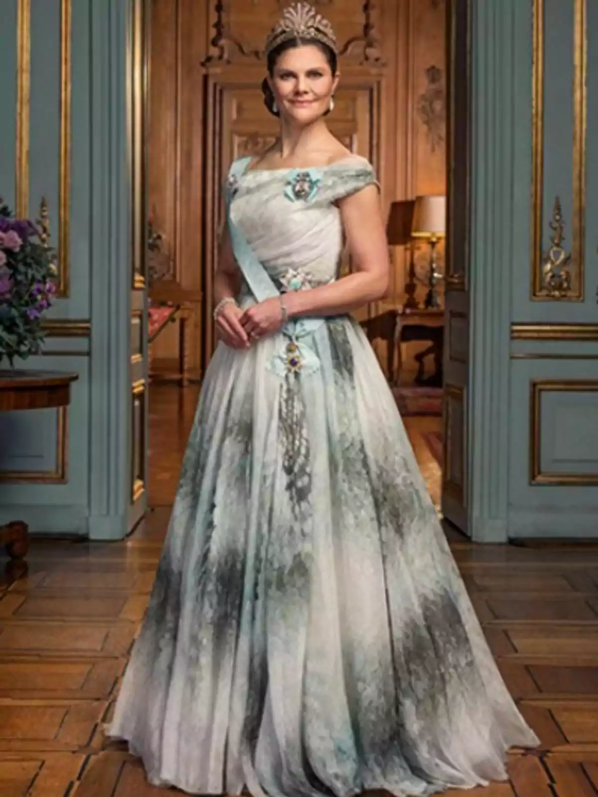 Princess Victoria of Sweden, in an elegant dress and a tiara, is standing in a room decorated with golden details and wood. Princess Victoria of Sweden, in an elegant dress and a tiara, is standing in a room decorated with golden details and wood.