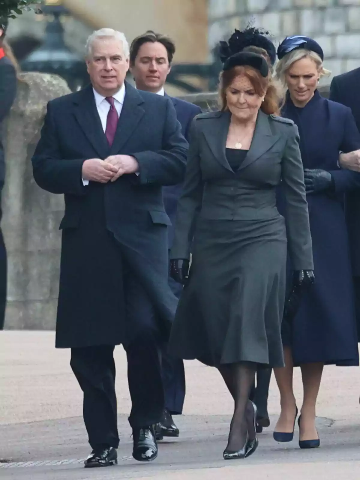Un grup de persones vestides formalment camina per un carrer, amb el príncep Andreu de cabell canós i Sarah Ferguson de cabell vermellós al capdavant. Un grup de persones vestides formalment camina per un carrer, amb el príncep Andreu de cabell canós i Sarah Ferguson de cabell vermellós al capdavant.