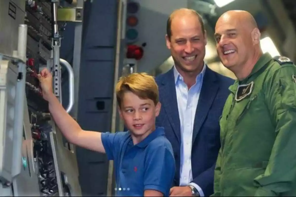 El príncipe George interactúa con un panel de control mientras el príncipe Guillermo y otro hombre sonríen a su lado en un entorno que parece ser una cabina de avión o simulador. Post en Instagram