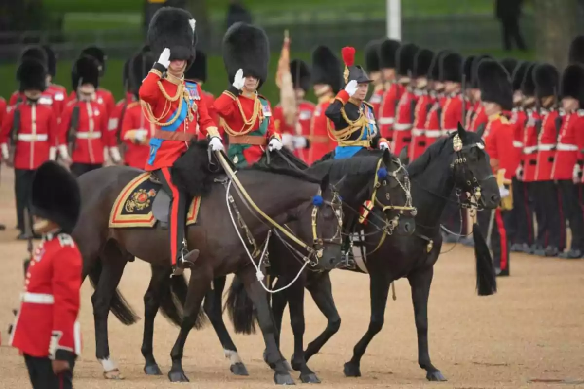 Desfilada militar amb soldats britànics uniformats muntant a cavall i saludant mentre altres soldats desfilen en formació al fons. Desfilada militar amb soldats britànics uniformats muntant a cavall i saludant mentre altres soldats desfilen en formació al fons.