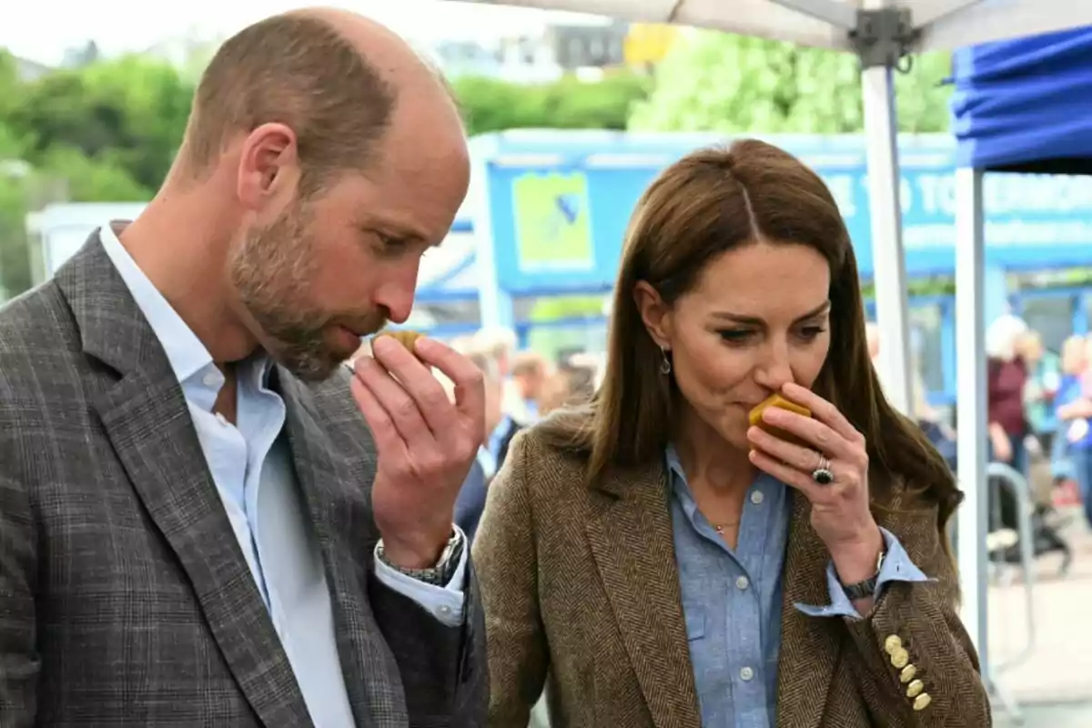 El príncep Guillem i Kate Middleton estan olorant fruites en un esdeveniment a l'aire lliure. El príncep Guillem i Kate Middleton estan olorant fruites en un esdeveniment a l'aire lliure.