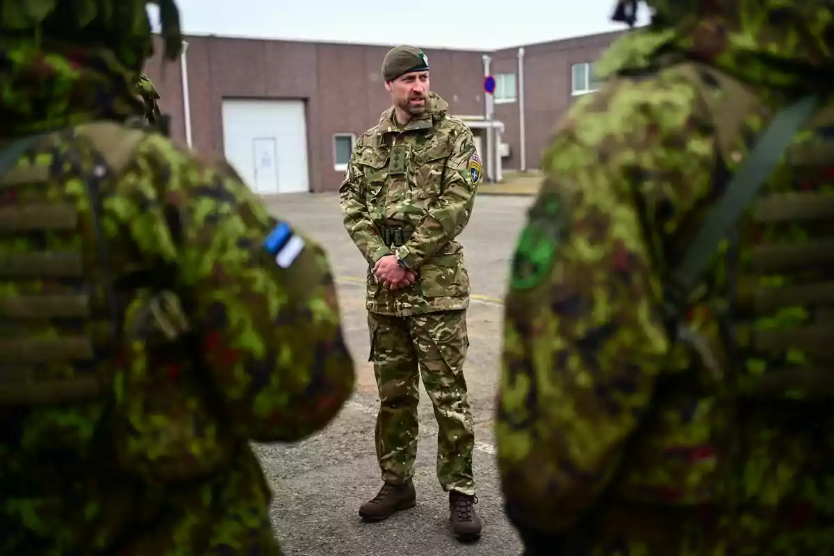 El príncep Guillem dret amb uniforme de camuflatge parla davant d’altres soldats en una zona exterior al costat d’un edifici. El príncep Guillem dret amb uniforme de camuflatge parla davant d’altres soldats en una zona exterior al costat d’un edifici.