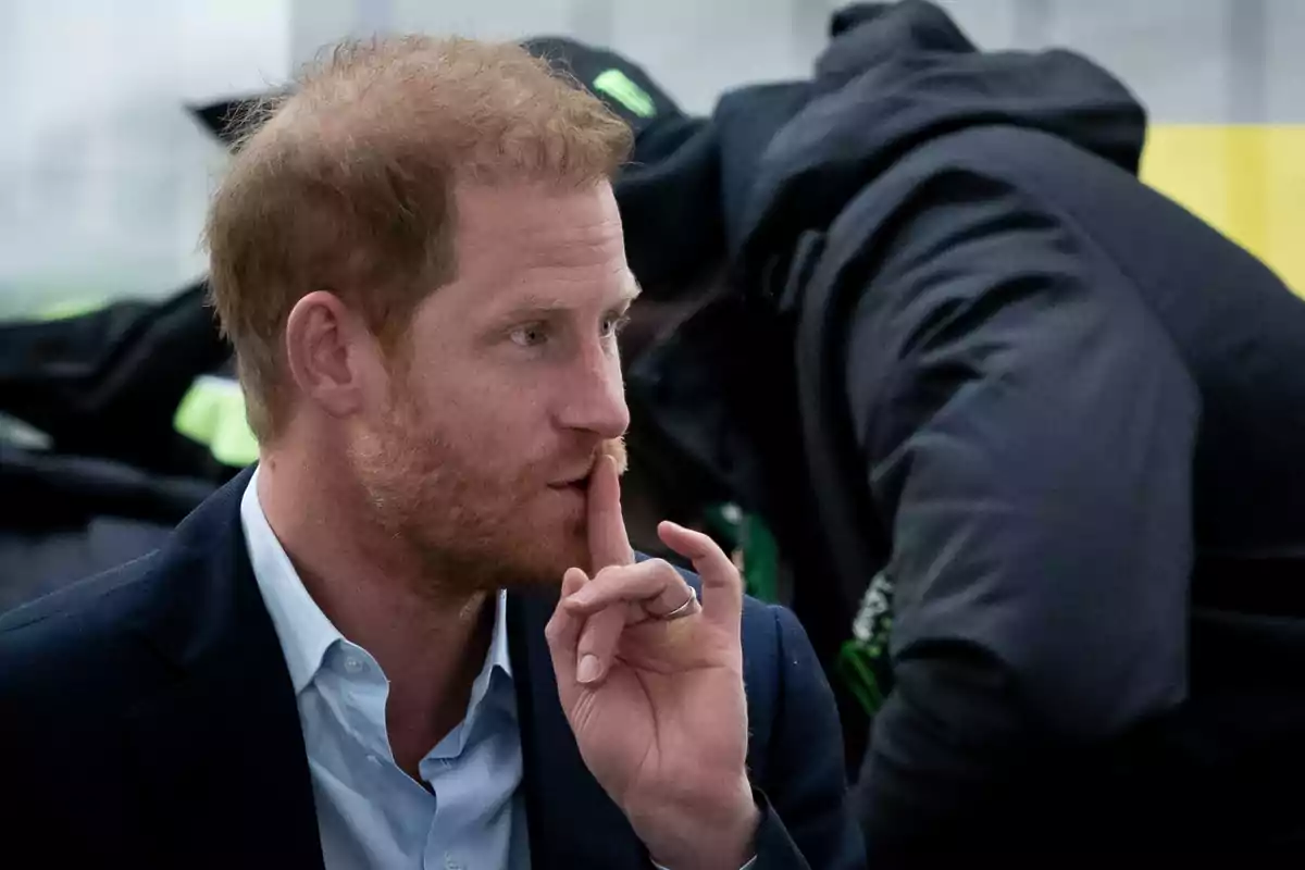 El príncep Harry amb barba fa un gest de silenci amb el dit índex sobre els llavis mentre porta posat un vestit fosc i una camisa clara. El príncep Harry amb barba fa un gest de silenci amb el dit índex sobre els llavis mentre porta posat un vestit fosc i una camisa clara.