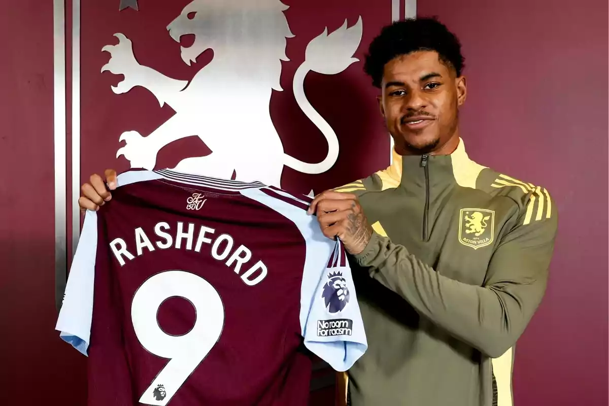 Un jugador de fútbol sostiene una camiseta del Aston Villa con el número 9 y el nombre Un jugador de fútbol sostiene una camiseta del Aston Villa con el número 9 y el nombre