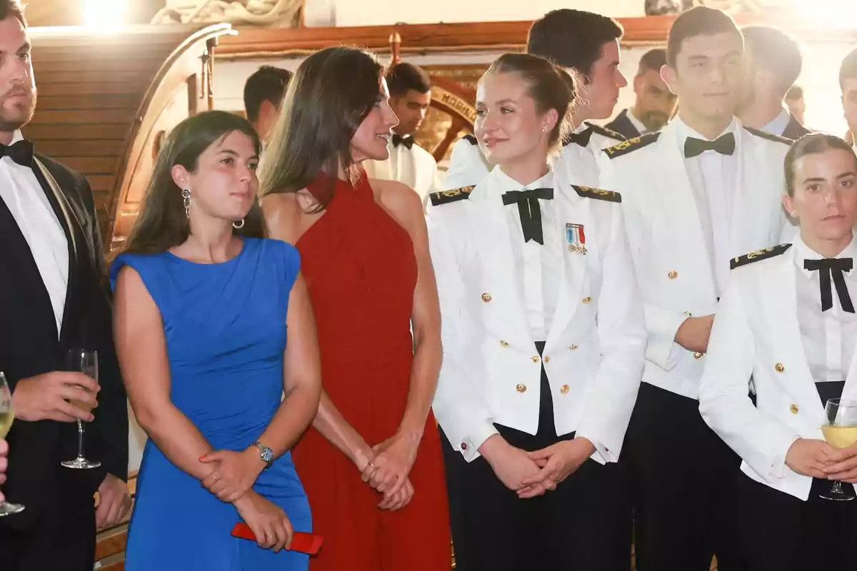 La reina Letizia i la princesa Leonor vestides formalment, algunes amb uniformes blancs i altres amb vestits de gala, en un esdeveniment social. La reina Letizia i la princesa Leonor vestides formalment, algunes amb uniformes blancs i altres amb vestits de gala, en un esdeveniment social.