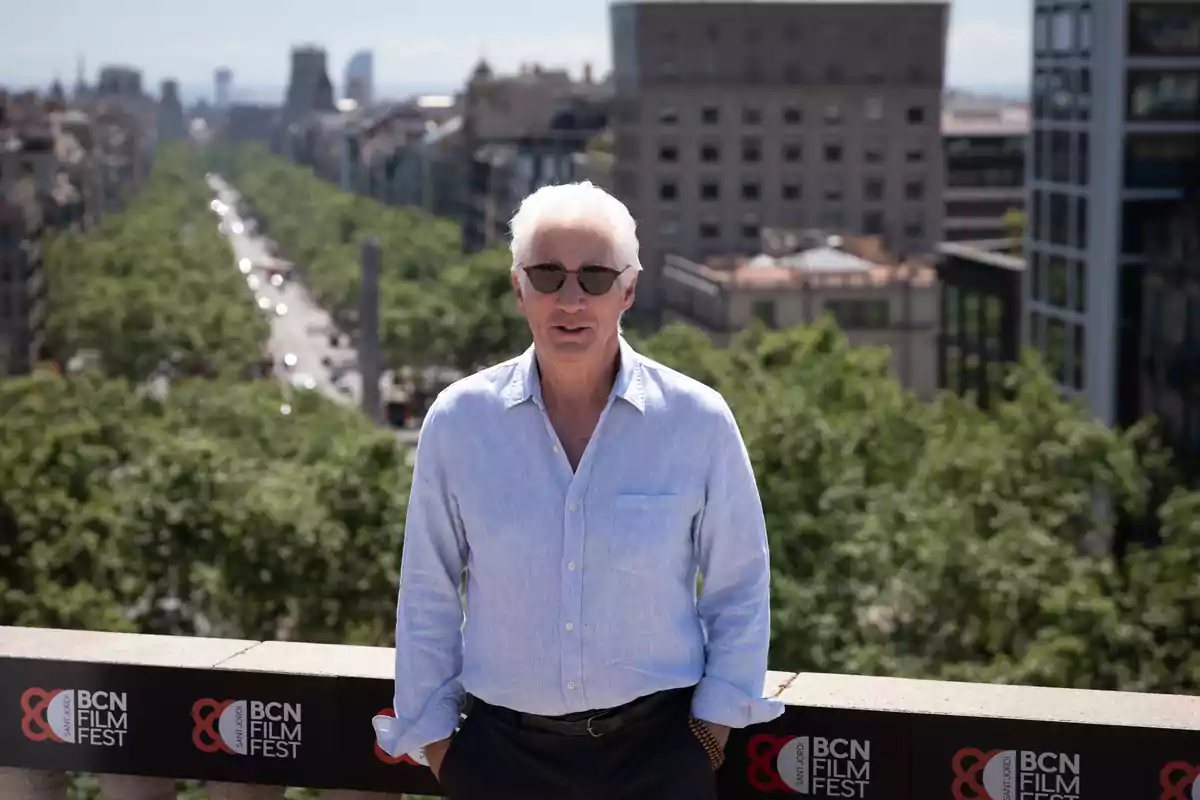 Richard Gere in a blue jersey and sunglasses poses in front of an urban landscape with trees and buildings in the background, next to a BCN Film Fest sign. Richard Gere in a blue jersey and sunglasses poses in front of an urban landscape with trees and buildings in the background, next to a BCN Film Fest sign.
