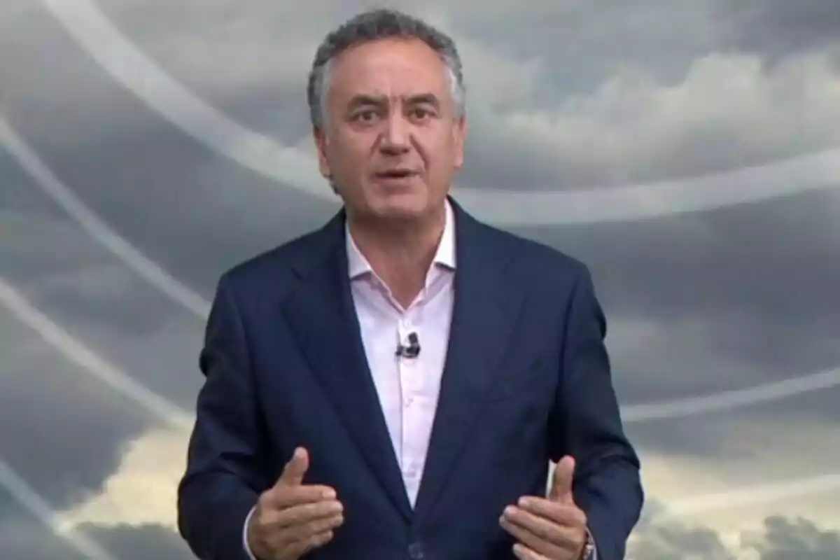 Pla mitjà de Roberto Brasero vestit amb un vestit blau i camisa clara parlant davant d’un fons de núvols grisos. Pla mitjà de Roberto Brasero vestit amb un vestit blau i camisa clara parlant davant d’un fons de núvols grisos.