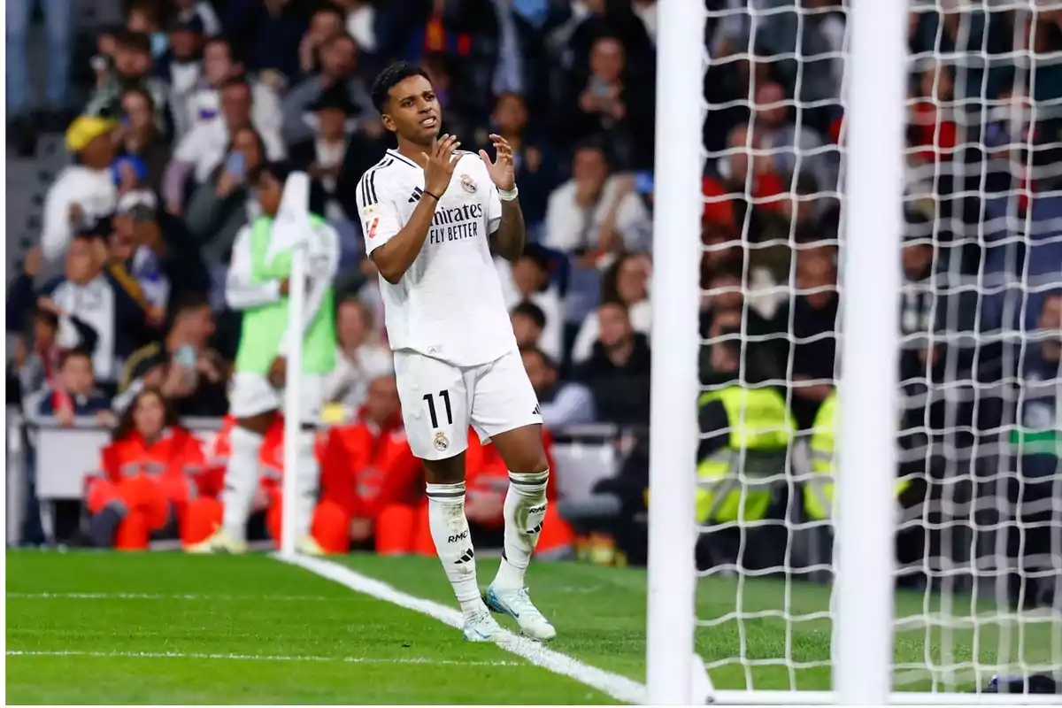 Real Madrid player wearing number 11 shows frustration in front of the goal during a match, with fans and staff in the background. Real Madrid player wearing number 11 shows frustration in front of the goal during a match, with fans and staff in the background.