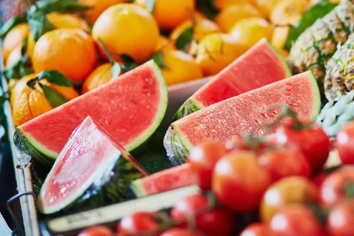 Síndries tallades a quarts i envoltades d'altres fruites en un supermercat